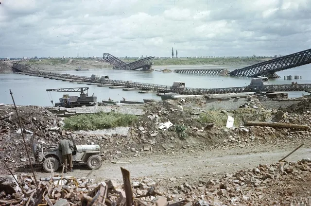 Trucks use a completed floating Bailey bridge over the River Po, alongside the remains of an earlier bridge, in 1945.
