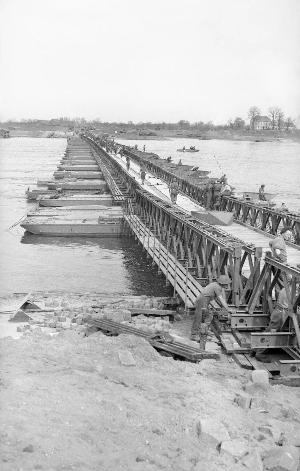 Engineers work on the steel panels and decking of a Bailey bridge stretching across the Rhine in 1945.